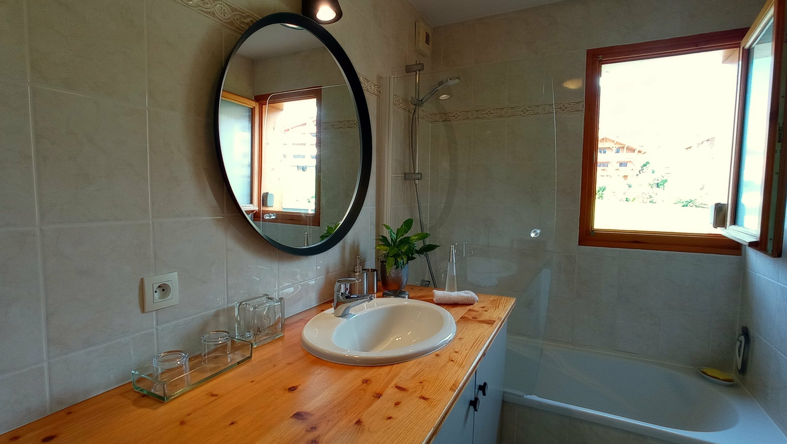 Salle de bain avec baignoire, vasque, sèche cheveux, lave linge